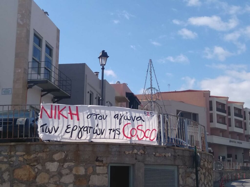 Πανώ που γράφει ΝΙΚΗ στον αγώνα των εργατών της COSCO αναρτημένο στην πασαρέλα στο Ρέθυμνο