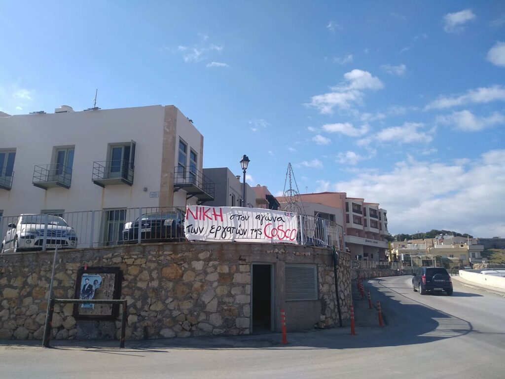 Πανώ που γράφει ΝΙΚΗ στον αγώνα των εργατών της COSCO αναρτημένο στην πασαρέλα στο Ρέθυμνο